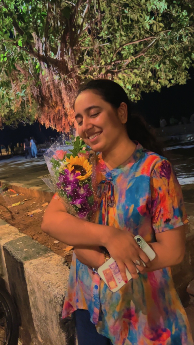 Unnu holding a colorful bouquet beneath the city lights